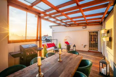 a patio with a wooden table and chairs at A/C LUX Rooftop APT 6BR+3.5Bath Wenceslas square in Prague