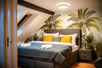 a bedroom with a bed with yellow pillows and palm trees at A/C LUX Rooftop APT 6BR+3.5Bath Wenceslas square in Prague