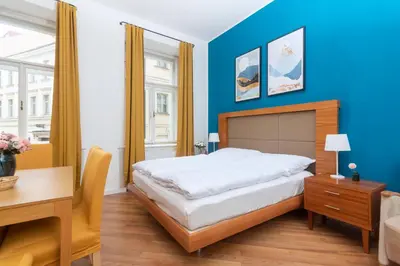 a bedroom with a bed and a table and a desk at Moonlight Apartments Old Town in Prague