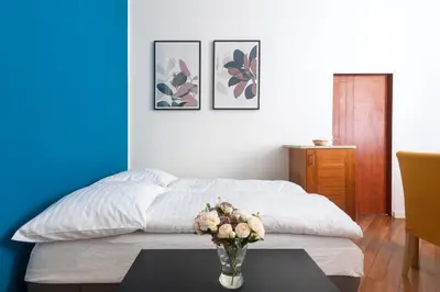 a bedroom with a bed and a table with a vase of flowers at Moonlight Apartments Old Town in Prague