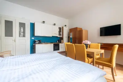 a bedroom with a bed and a table and chairs at Moonlight Apartments Old Town in Prague
