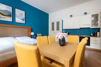a room with a table with yellow chairs and a bed at Moonlight Apartments Old Town in Prague