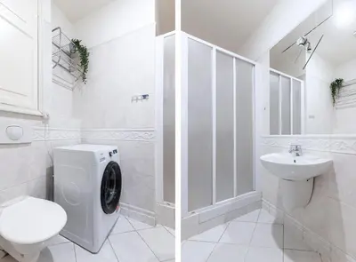 a white bathroom with a toilet and a sink at Moonlight Apartments Old Town in Prague