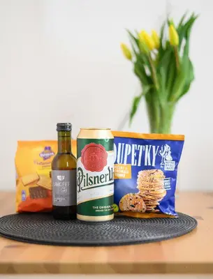 a table with a bottle of beer and a bag of snacks at Cosy central apartment in Žižkov in Prague