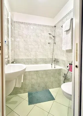 a bathroom with a tub and a sink and a toilet at Cosy central apartment in Žižkov in Prague