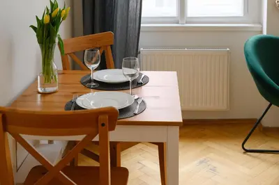 a wooden table with two glasses of wine on it at Cosy central apartment in Žižkov in Prague