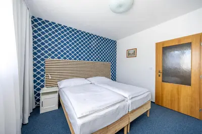 a bedroom with a bed and a blue tiled wall at Marina Vltava in Nelahozeves