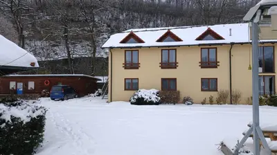 a yellow house with snow on the roof at Marina Vltava in Nelahozeves