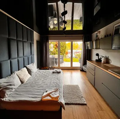 a bedroom with a bed and a kitchen with a window at Appartment Pruhonice & terrace in Pruhonice