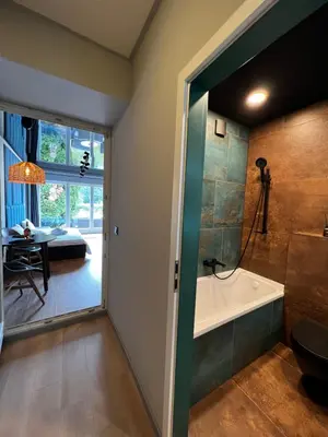 a bathroom with a shower and a tub and a bedroom at Appartment Pruhonice & terrace in Pruhonice