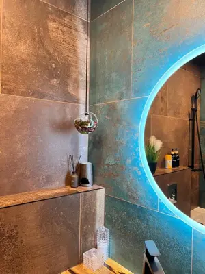 a bathroom with a circular mirror on the wall at Appartment Pruhonice & terrace in Pruhonice
