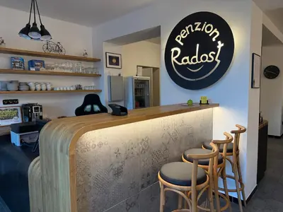 a bar with two stools and a sign on the wall at Penzion Radost in Poděbrady