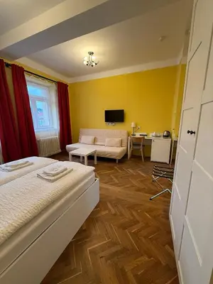 a bedroom with a bed and a living room at Penzion Radost in Poděbrady