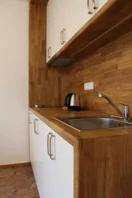 a kitchen with a sink and white cabinets at Penzion Radost in Poděbrady