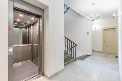 a hallway of a building with a glass door and stairs at Cozy quiet new apartment in Karlin square in Prague