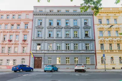 a large building with cars parked in front of it at Cozy quiet new apartment in Karlin square in Prague