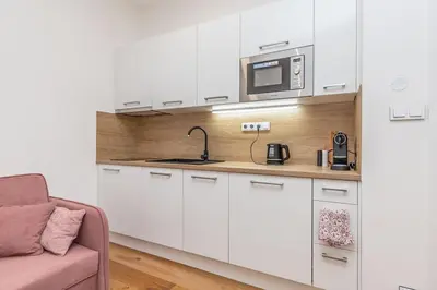 a kitchen with white cabinets and a microwave at Cozy quiet new apartment in Karlin square in Prague