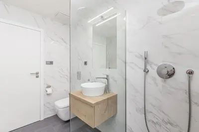 a white bathroom with a shower and a toilet at Cozy quiet new apartment in Karlin square in Prague