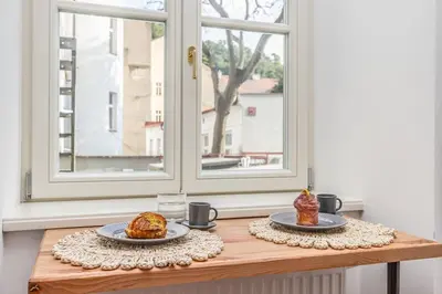 two plates of food on a table with a window at Cozy quiet new apartment in Karlin square in Prague