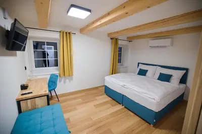 a bedroom with a bed and a desk and a television at Penzion pod Hazmburkem in Klapý