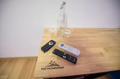 a table with two remote controls and a vase at Penzion pod Hazmburkem in Klapý
