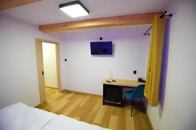 a bedroom with a desk and a bed and a room at Penzion pod Hazmburkem in Klapý