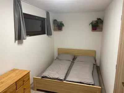 a small bedroom with a bed and a window at Bydlení v zahradě in Bratronice