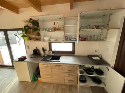 a kitchen with a counter with a sink and shelves at Bydlení v zahradě in Bratronice