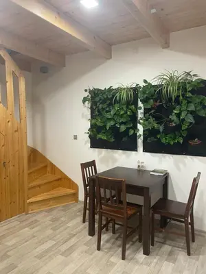 a dining room with a table and chairs and plants on the wall at Bydlení v zahradě in Bratronice