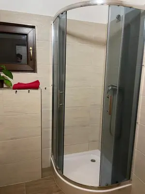 a shower with a glass door in a bathroom at Bydlení v zahradě in Bratronice