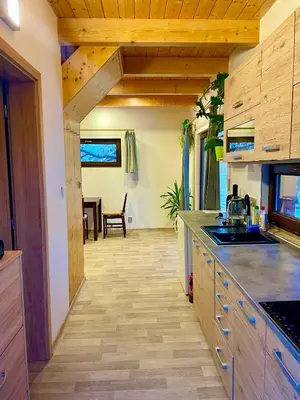 a kitchen with wooden cabinets and a table in the background at Bydlení v zahradě in Bratronice