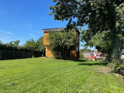 a house in a field with a tree at Bydlení v zahradě in Bratronice