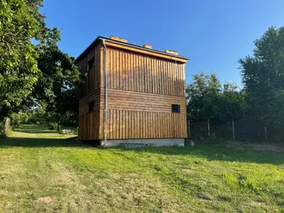 a wooden building sitting in a grass field at Bydlení v zahradě in Bratronice