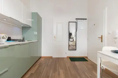 a bedroom with a white bed and a large window at Stay Inn Apartments U Stundanky in Prague