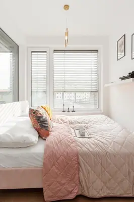 a bedroom with a large bed with a large window at Prague Days - Studio with Balcony in quiet and trendy Holešovice in Prague