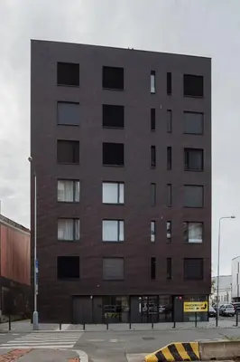 a large brick building on a city street at Prague Days - Studio with Balcony in quiet and trendy Holešovice in Prague