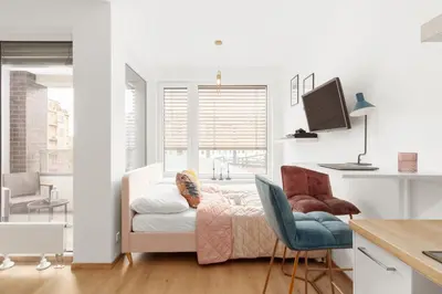a white living room with a couch and a desk at Prague Days - Studio with Balcony in quiet and trendy Holešovice in Prague