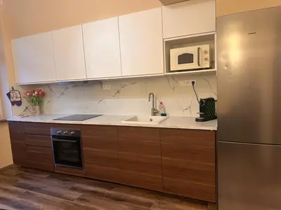 a kitchen with white cabinets and a sink and a refrigerator at Eva's Apartment Prague in Prague