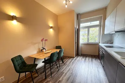 a kitchen with a wooden table and green chairs at Eva's Apartment Prague in Prague