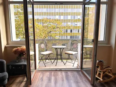 a patio with a table and chairs on a balcony at Eva's Apartment Prague in Prague