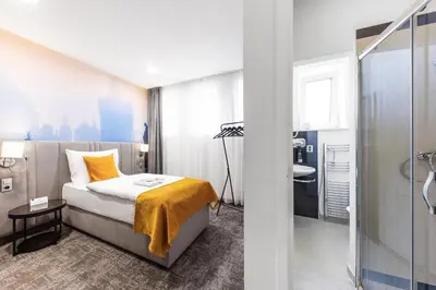a hotel room with a bed and a bathroom at A1 Royal Plaza in Prague