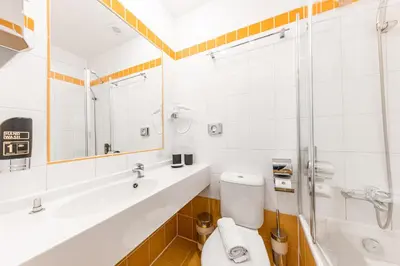 a bathroom with a toilet and a sink and a shower at A1 Royal Plaza in Prague
