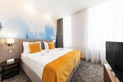 a hotel room with a large bed and a tv at A1 Royal Plaza in Prague
