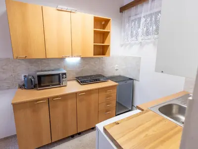 a small kitchen with a sink and a microwave at Holiday Home Zimořský domek by Interhome in Dolní Zimoř