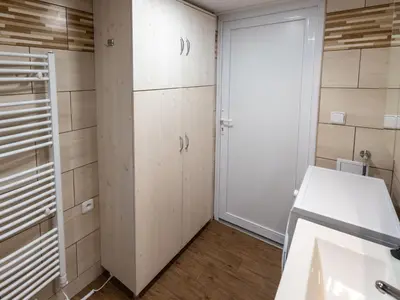 a small bathroom with a washing machine and a sink at Holiday Home Zimořský domek by Interhome in Dolní Zimoř