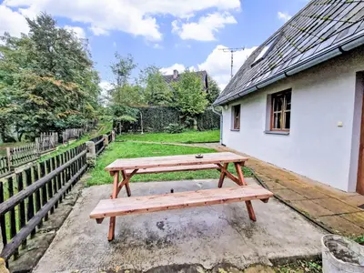 a wooden picnic table sitting next to a building at Holiday Home U skály by Interhome in Horní Vidim
