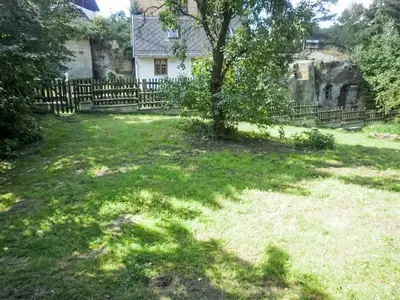 a yard with a tree in front of a fence at Holiday Home U skály by Interhome in Horní Vidim