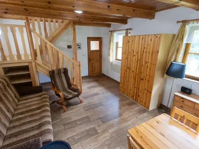 a living room with a staircase and a chair at Holiday Home U skály by Interhome in Horní Vidim