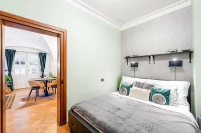 a bedroom with a large bed and a dining room at Adam's Apartment - Best Location in Prague