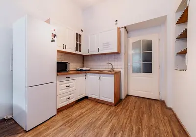 a kitchen with white cabinets and a white refrigerator at Hostel DO-RE-MI in Prague